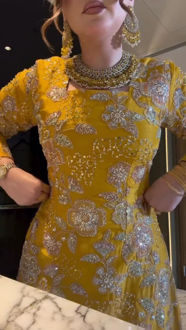 8 Alternative Wedding Dresses for Every Kind of Modern Bride 6 Person wearing a mustard yellow embroidered garment with heavy silver floral patterns and ornate jewelry.