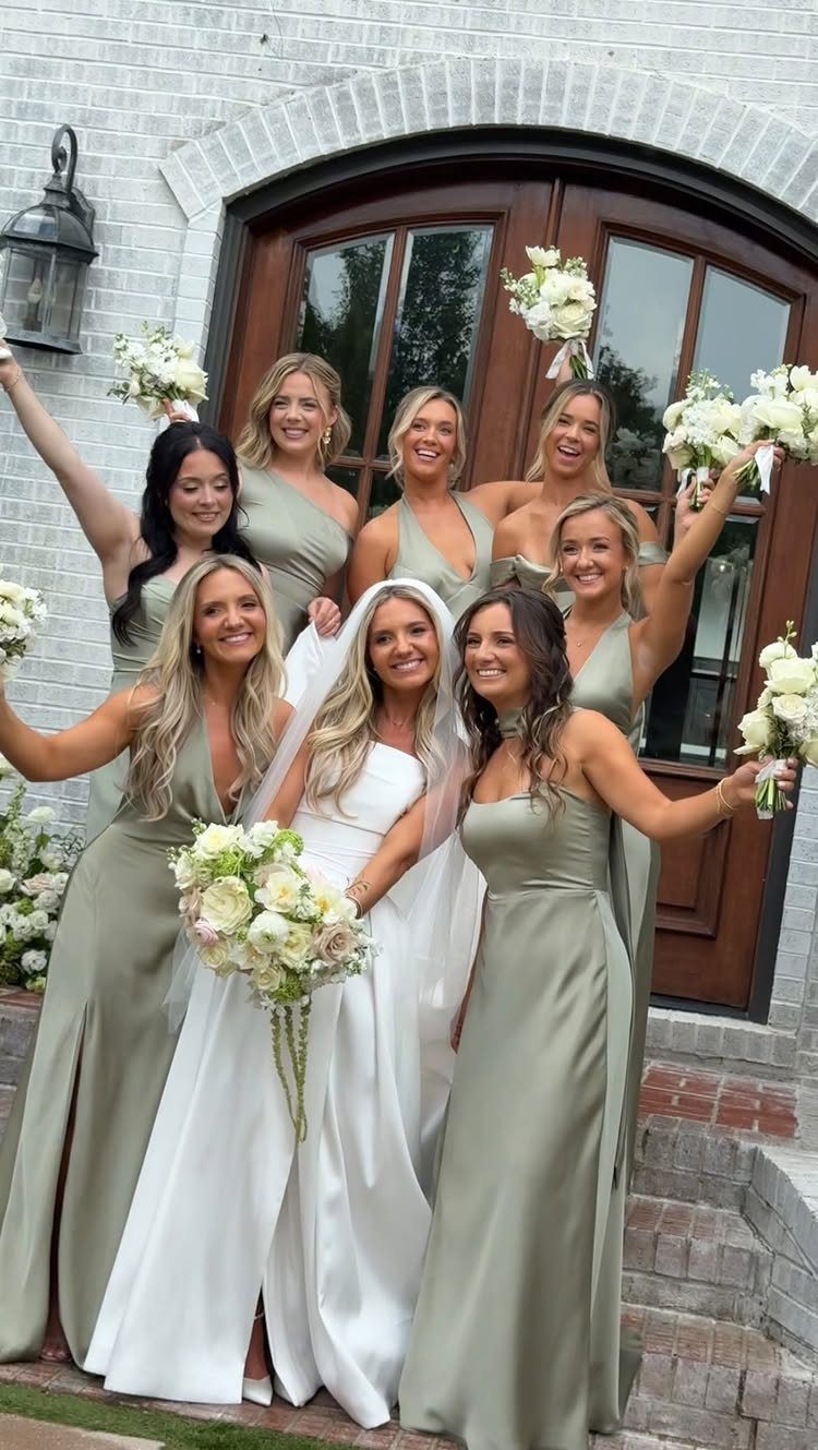 9 Champagne and Green Wedding Ideas for Every Detail 6 Bridesmaids in sage green dresses posing with a bride holding white flowers.