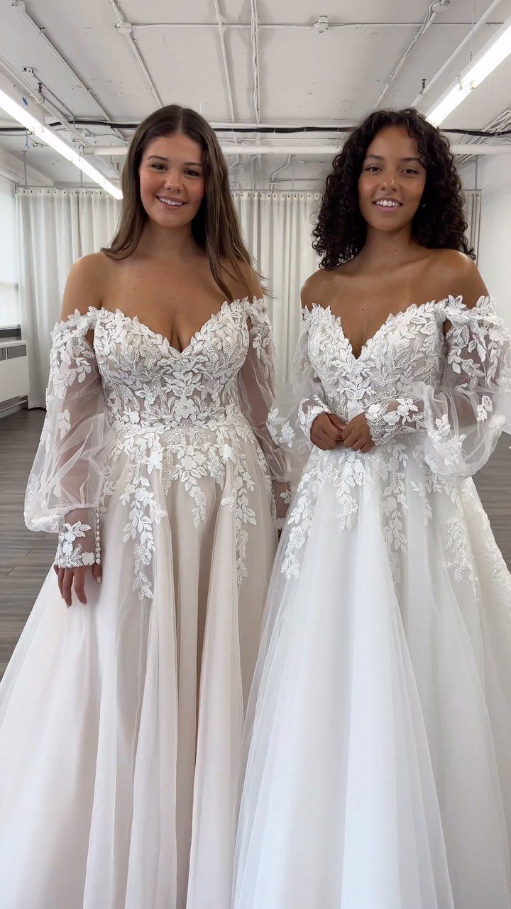 Champagne and Ivory: 3 Wedding Color Ideas That Actually Work 3 Two women smiling in white lace off-the-shoulder wedding dresses with long sheer sleeves.