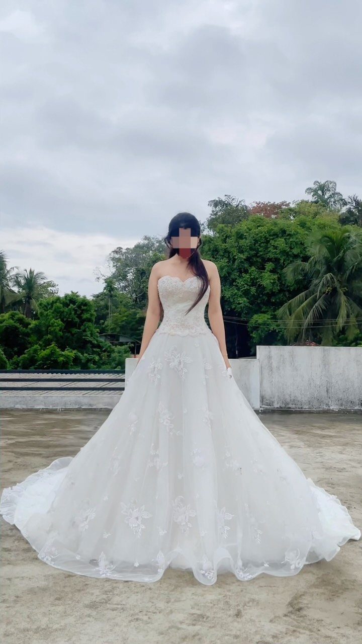 Champagne and Ivory: 3 Wedding Color Ideas That Actually Work 2 A woman wearing a strapless ivory lace wedding dress standing on a rooftop outdoors.