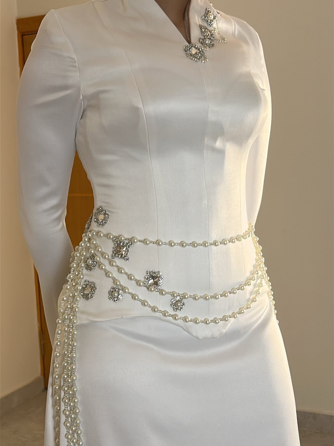 Church Wedding Dress: 10 Styles for the Ceremony 10 White satin wedding dress adorned with a pearl belt and silver floral jewelry accents.