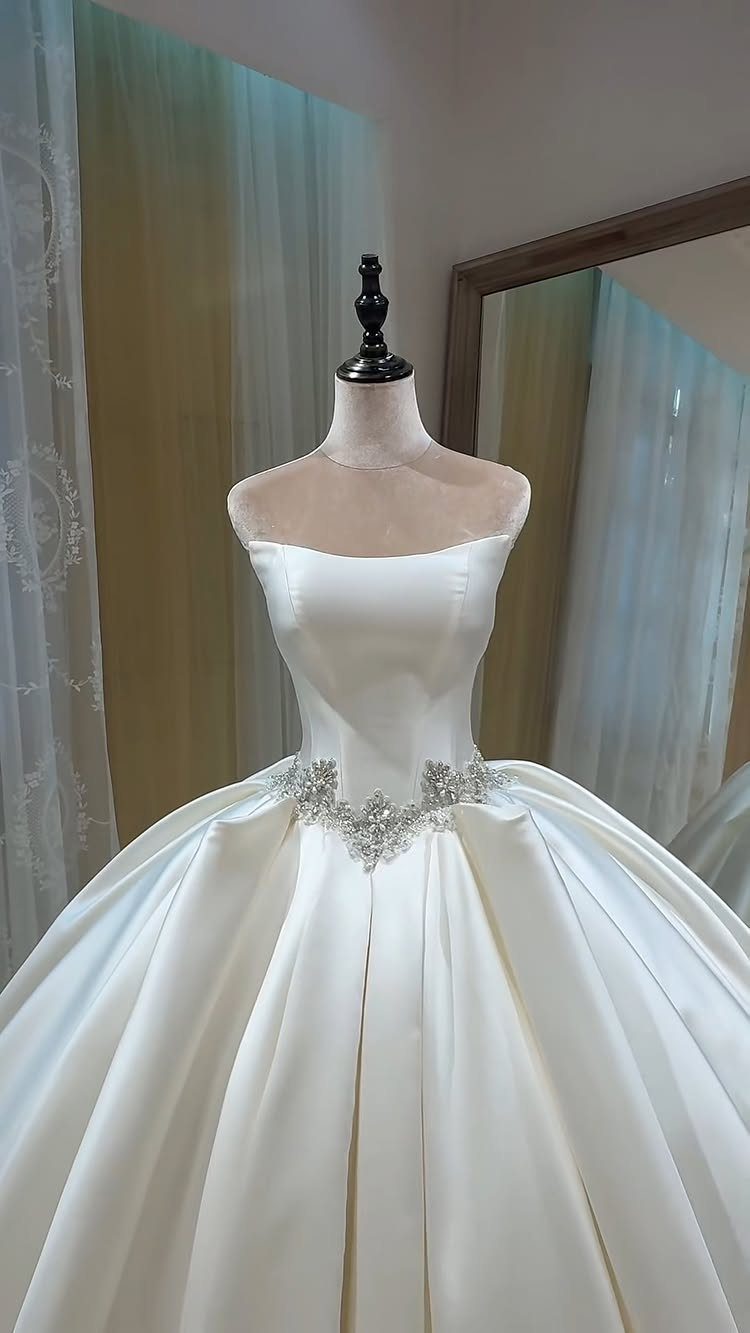 Church Wedding Dress: 10 Styles for the Ceremony 4 A white satin ball gown with crystal waist embellishments displayed on a mannequin.