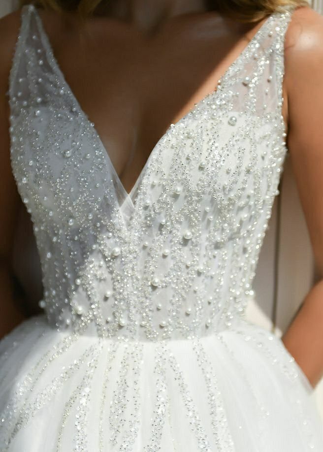 Church Wedding Dress: 10 Styles for the Ceremony 9 Close-up of a white wedding dress bodice decorated with intricate silver beads and pearls.