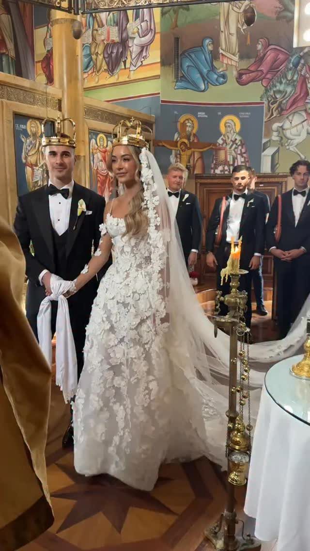 Church Wedding Dress: 10 Styles for the Ceremony 5 A bride in a white lace wedding dress and veil stands with her groom in a church.