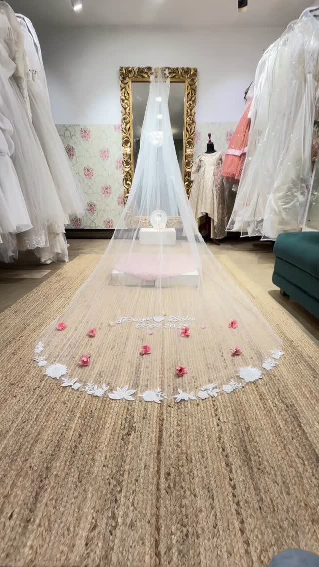 Church Wedding Dress: 10 Styles for the Ceremony 8 A long white tulle wedding veil with floral lace embroidery displayed on a mannequin.