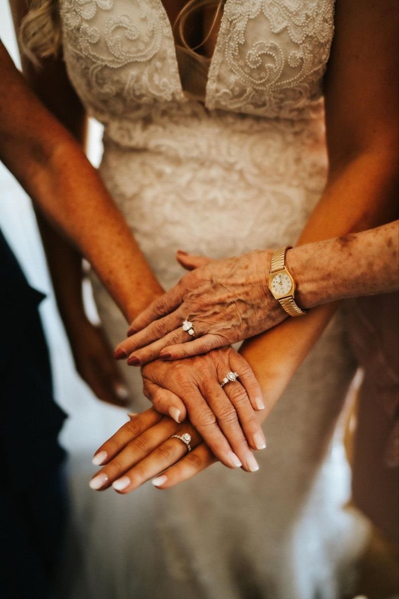 9 Family Wedding Picture Ideas for Every Group 8 Three hands with wedding rings stacked together over a white lace wedding dress.