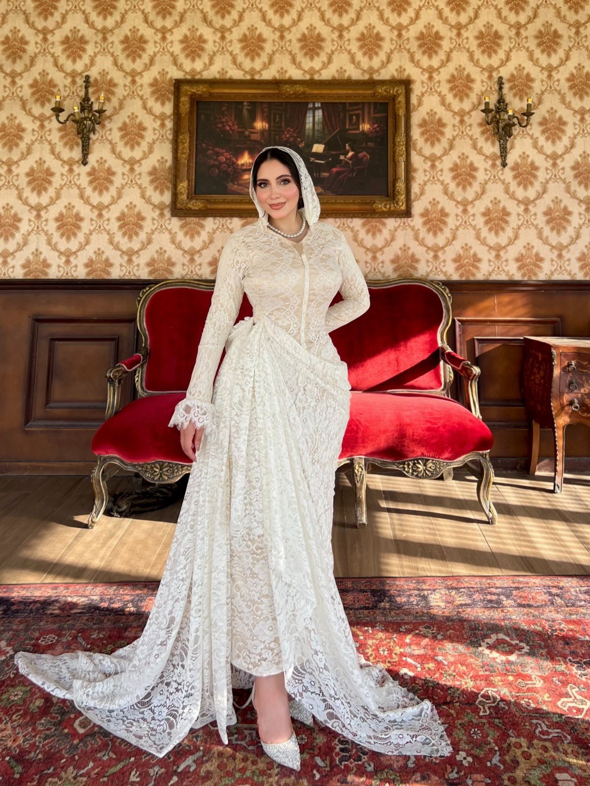 Hooded Wedding Dress: 6 Ideas from Vintage to Modern 3 Woman wearing a white lace wedding dress with an attached hood standing in a vintage room.