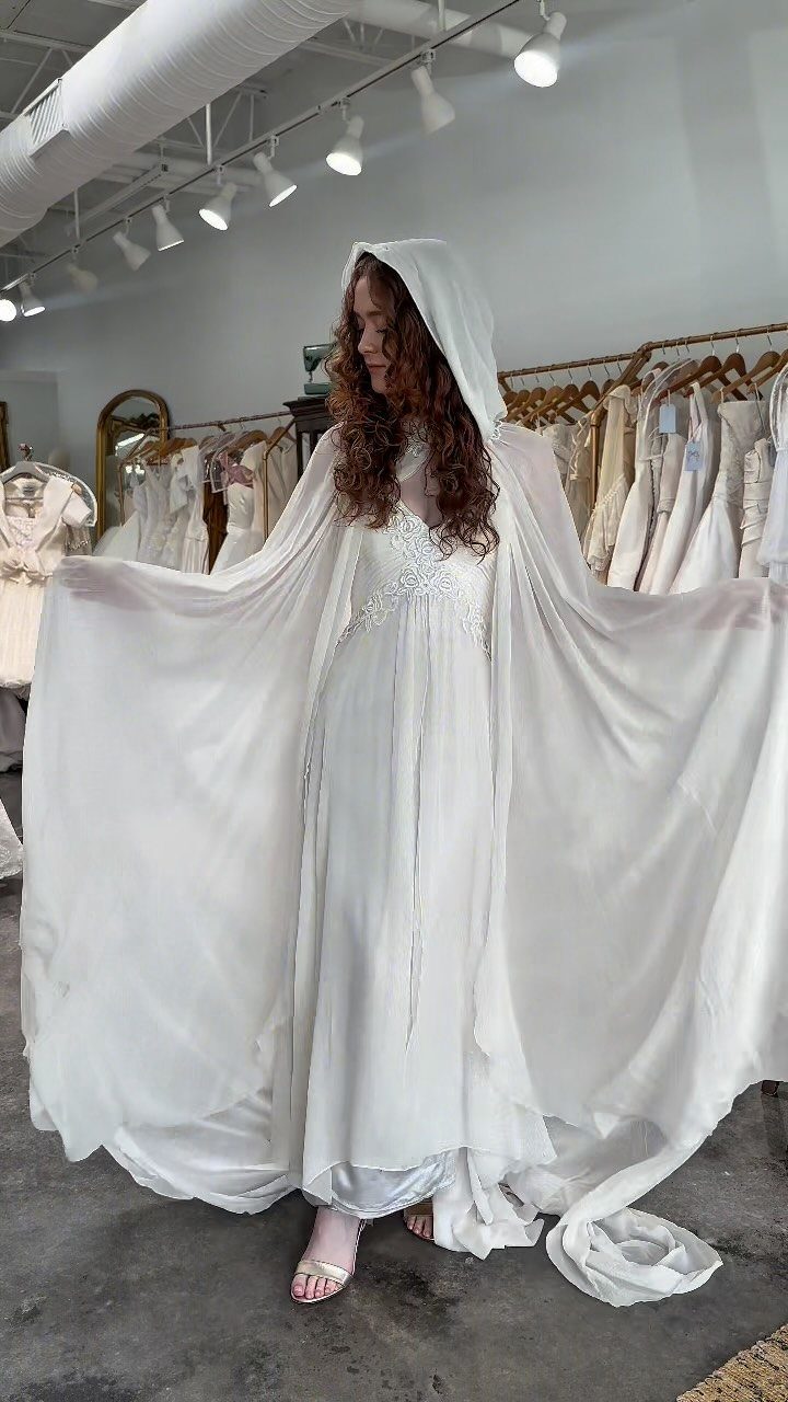 Hooded Wedding Dress: 6 Ideas from Vintage to Modern 2 A woman wearing a white wedding dress with a long, flowing, hooded sheer cape.