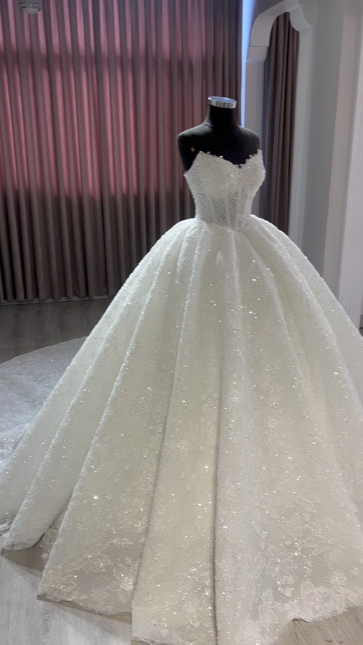 Lace Ball Gowns: 6 Silhouettes and Styles for Your Wedding 3 A sparkling white lace ball gown wedding dress displayed on a mannequin.