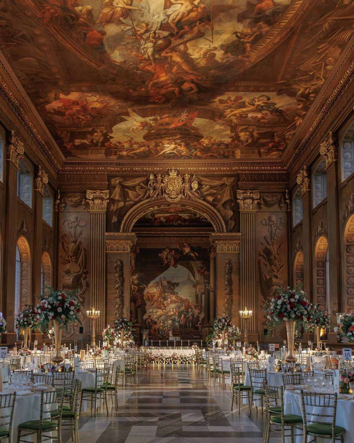 Mansion Wedding Venue Ideas: 17 Estate Settings for 2026 4 An opulent grand ballroom featuring a massive classical ceiling fresco and elegantly set dining tables.