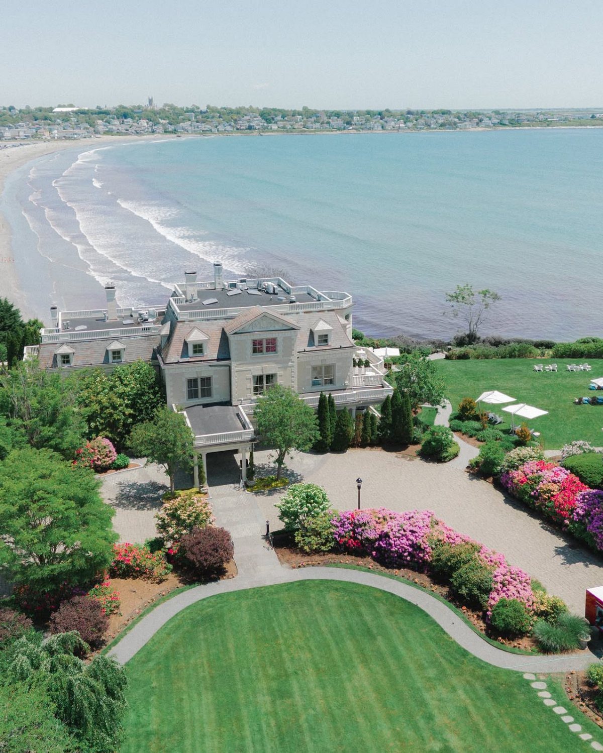 15 Most Beautiful Wedding Venues for 2026 6 A large coastal estate with lush gardens overlooking a sandy beach and the ocean.