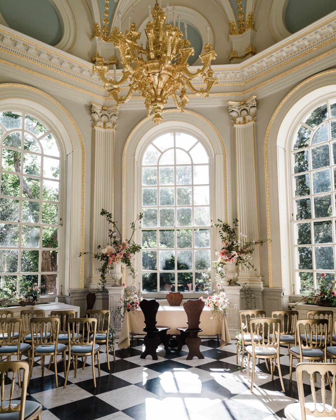 15 Most Beautiful Wedding Venues for 2026 10 Elegant indoor wedding venue with arched windows, gold chandelier, and checkered floor.
