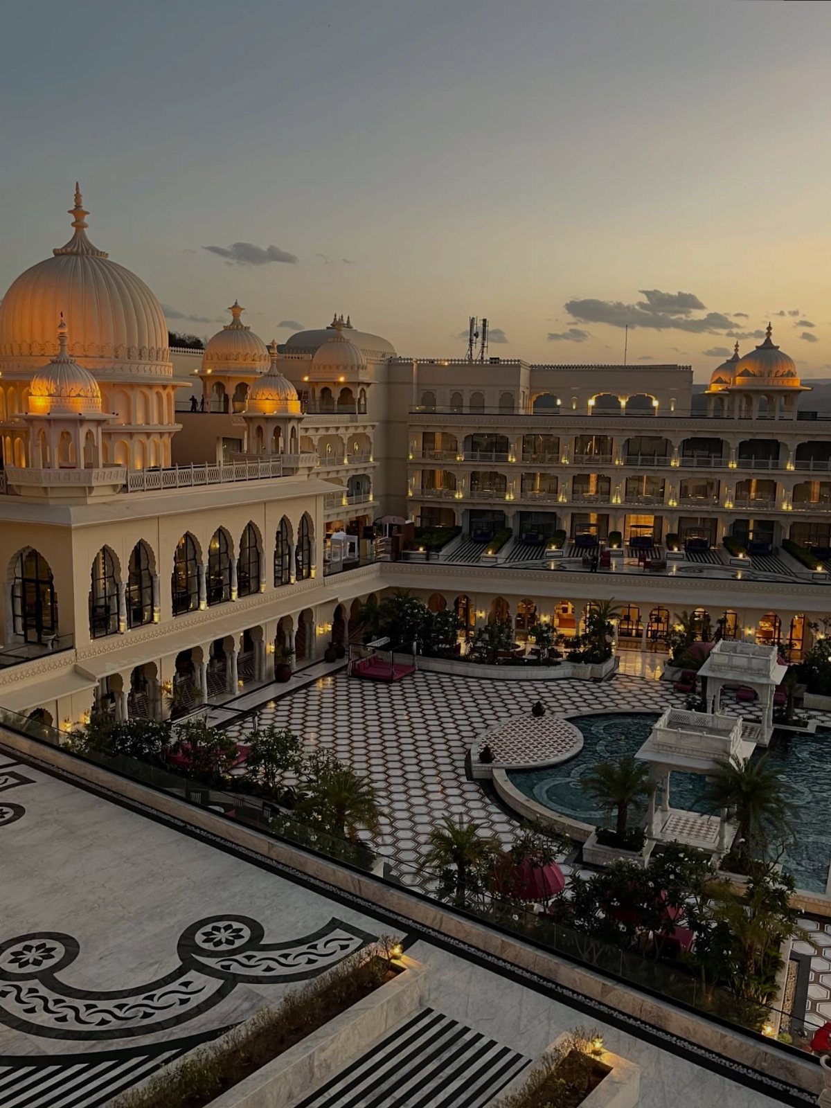 15 Most Beautiful Wedding Venues for 2026 11 A large luxury hotel with golden domes overlooking a patterned courtyard and swimming pool at dusk.
