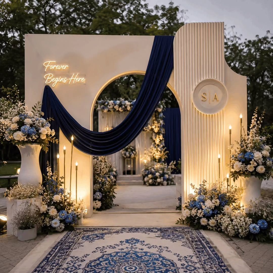 White wedding archway decorated with royal blue drapery and blue and white floral arrangements.