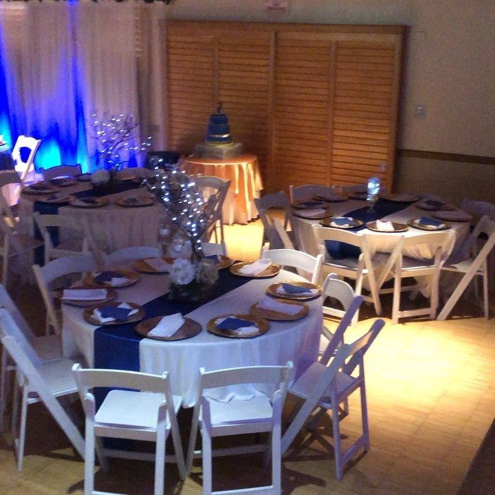 Banquet tables decorated with royal blue runners and white linens in a wedding reception hall.