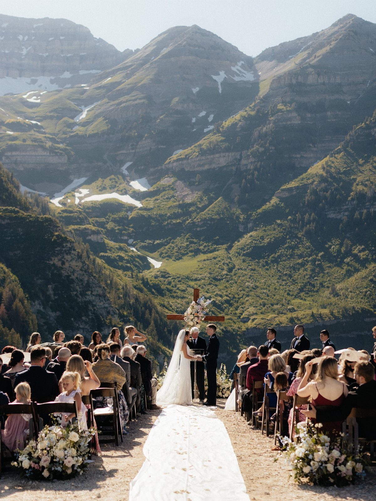 A bride and groom exchange vows at an outdoor mountain wedding ceremony.