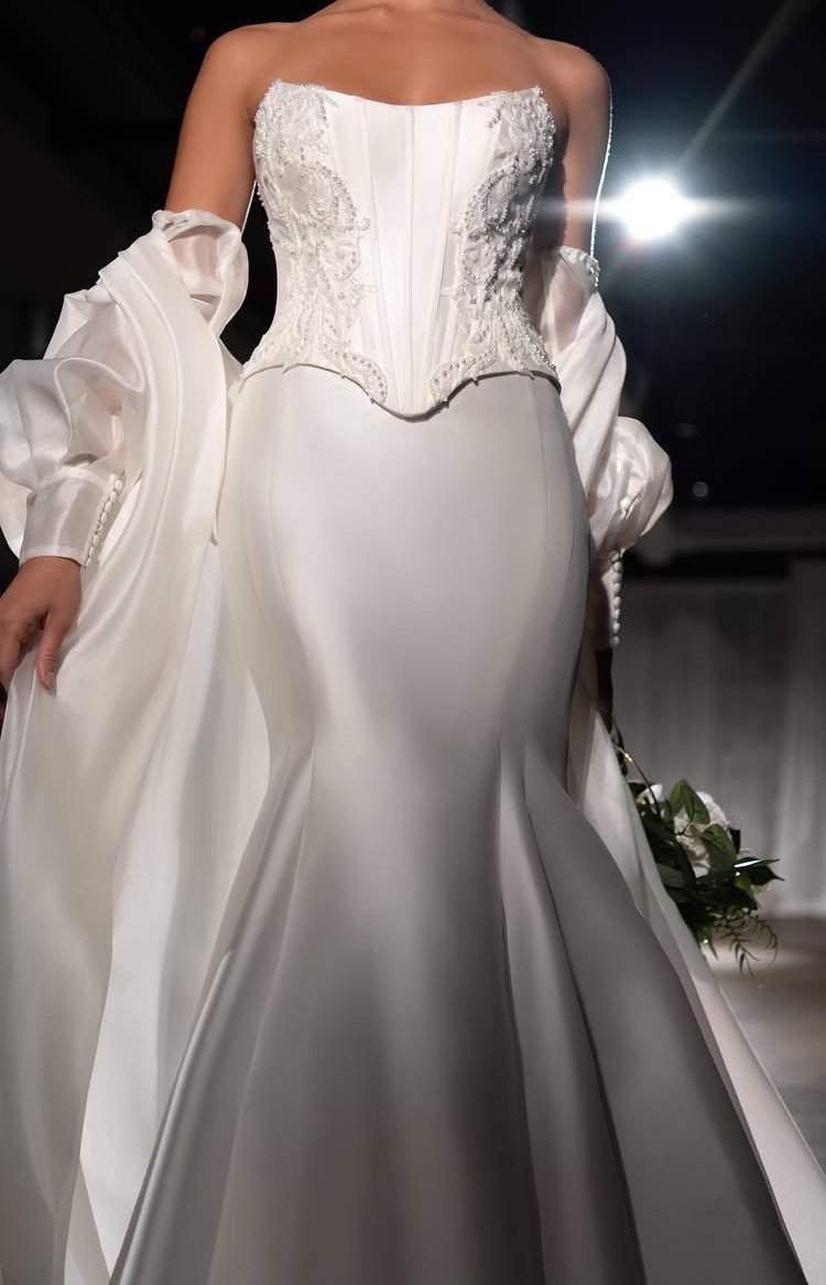 Wedding Dress Fabrics: 4 Photos of Silk, Lace, Satin and Tulle 1 A woman wearing a white strapless wedding dress with a lace bodice and smooth skirt.