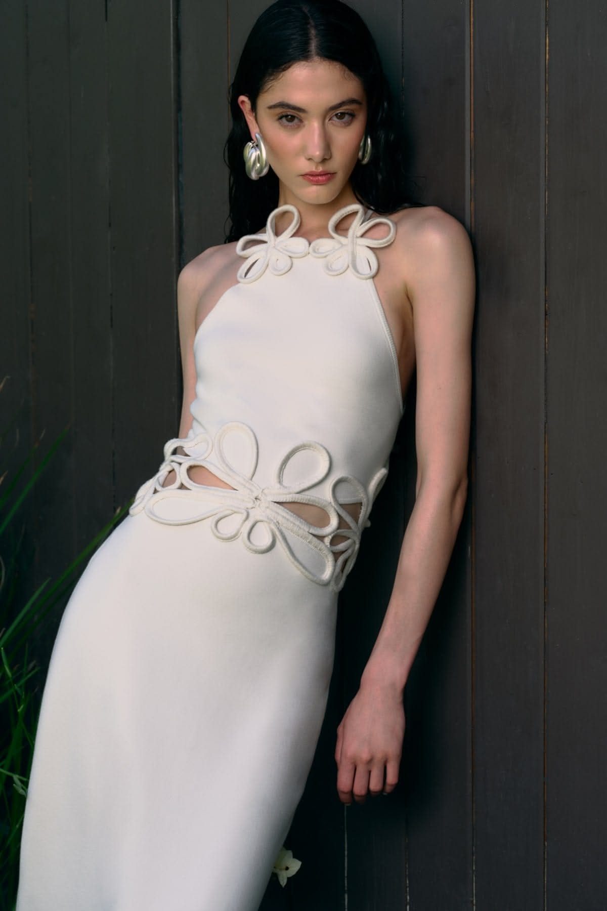 Wedding Dress Trends: 10 Looks for 2026 9 Woman in a white halter wedding dress featuring large sculptural floral cut-outs at the waist.