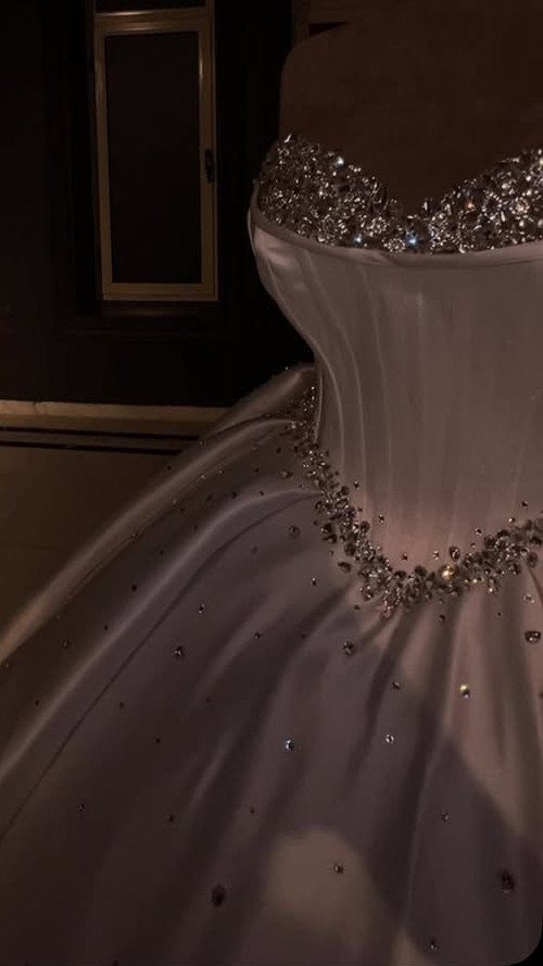 Wedding Dress Trends: 10 Looks for 2026 4 White satin wedding dress with sparkling crystal embellishments on the neckline and waist.