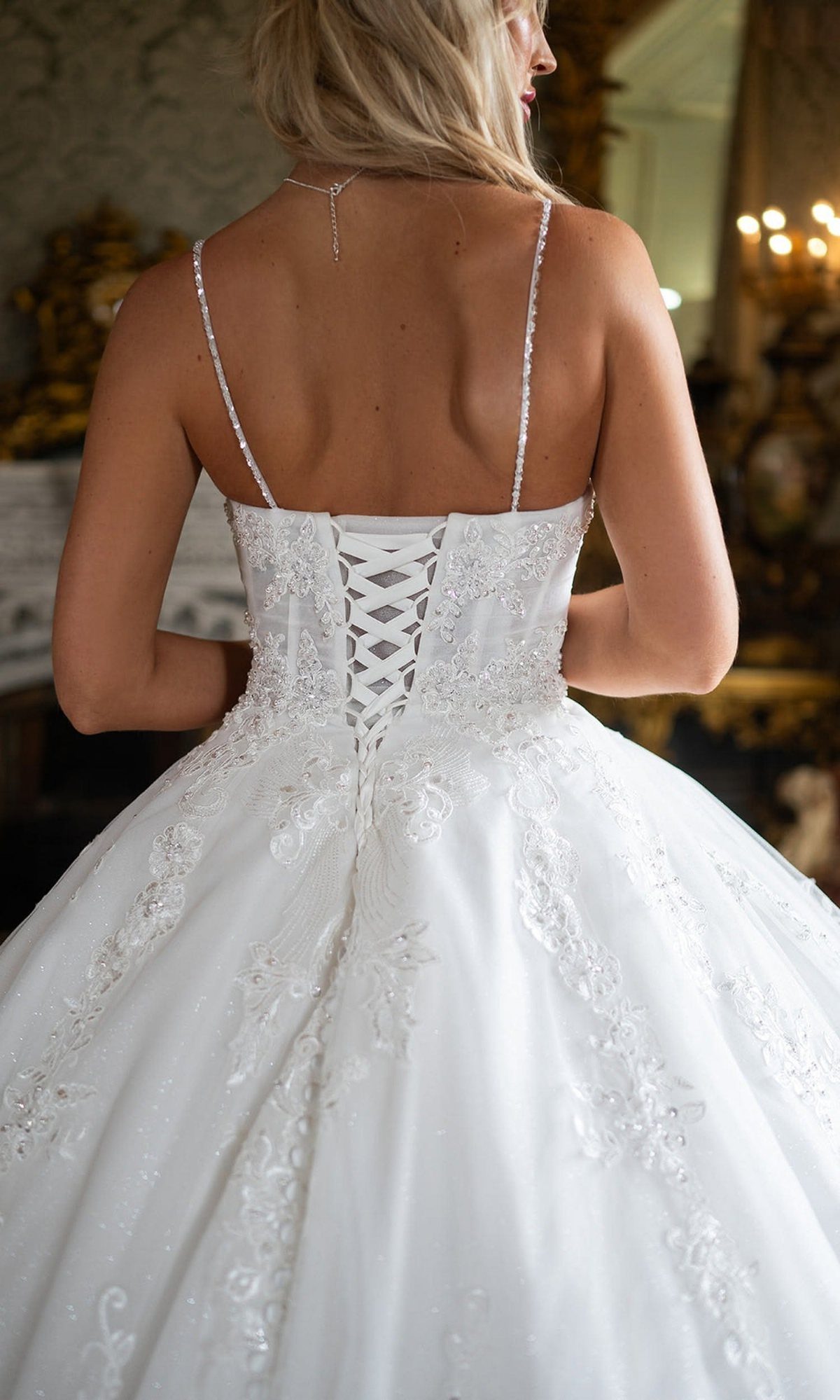 5 Wedding Dress with Bodice Ideas from Corset Gowns to Draped Satin 2 Back view of a woman in a white lace wedding dress with a lace-up corset closure.