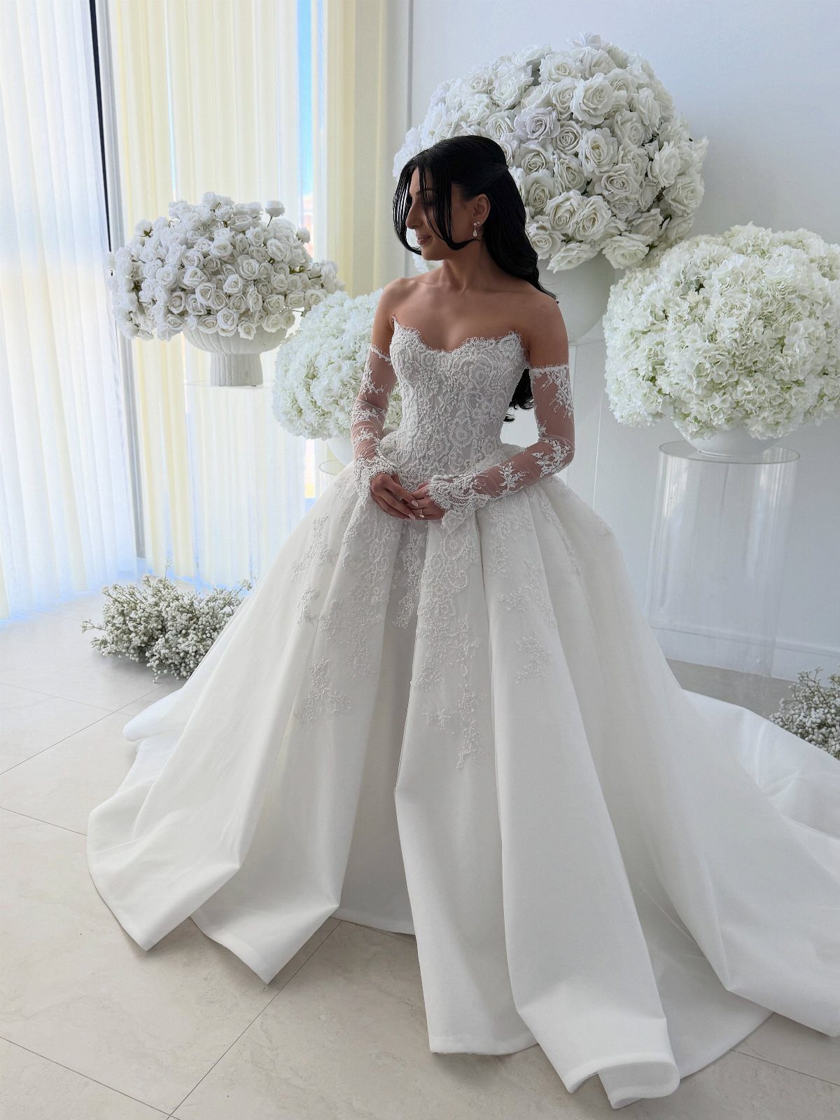 5 Wedding Dress with Bodice Ideas from Corset Gowns to Draped Satin 5 A woman wearing a white lace wedding dress with an intricate bodice and long sleeves.