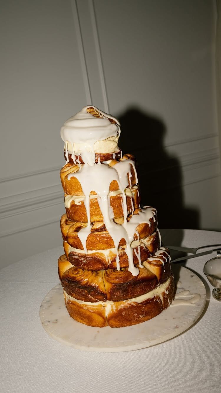 A tiered pastry cake with thick white icing dripping down the sides.